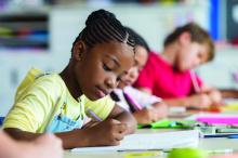 A girl and her classmates write in class